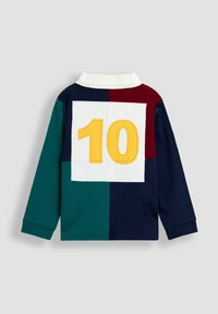 Koszula z długim rękawem, z białym kołnierzykiem, posiadająca wzór w technice color-blocking w kolorze granatowym, zielonym, burgundowym oraz dużą żółtą cyfrą "10" z tyłu.