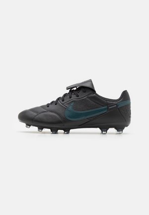 Schwarze Fußballschuhe mit einem glatten Lederobermaterial, türkisfarbenem Nike-Swoosh, Schnürverschluss und geformter Stollenanordnung für besseren Halt.