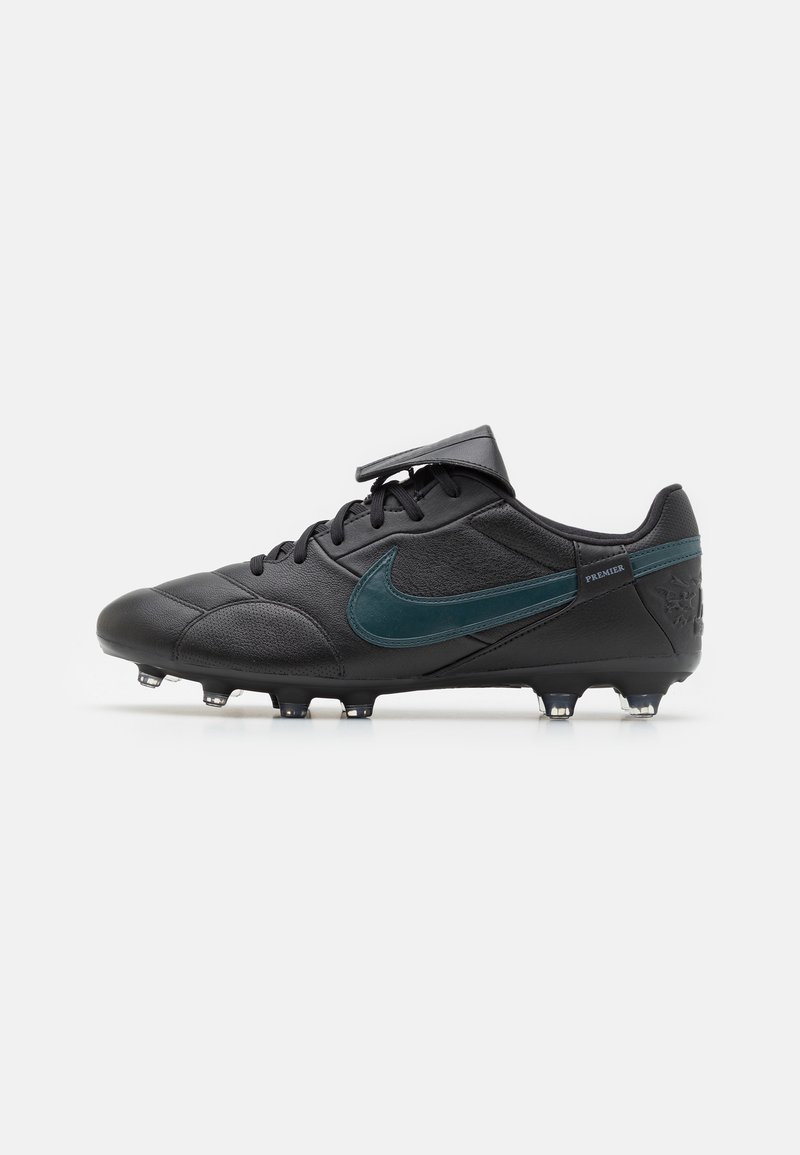 Crampons de football noirs avec une tige en cuir lisse, un swoosh Nike teal, un système de laçage et une configuration de crampons moulés pour une meilleure traction.
