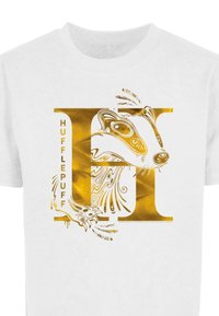 Balta T-krekls ar zeltītu stilizētu burtu "H", kuram ir sarežģīts ūdeles dizains un uzraksts "HUFFLEPUFF" dekoratīvā fontā.