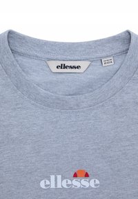 Camiseta de cuello redondo en gris claro con el logo blanco de ellesse y un diseño semicircular en rojo-naranja en la parte frontal, etiqueta de tamaño en el interior del cuello.
