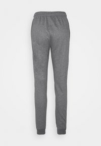 Pantalon de survêtement gris avec une texture douce, taille élastique et jambes fuselées. Ourlet aux chevilles, avec un design simple sans motifs.