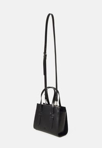 Sac à main en cuir noir avec deux courtes poignées et une longue sangle réglable. Présente une fermeture éclair, une texture lisse et un design minimaliste.