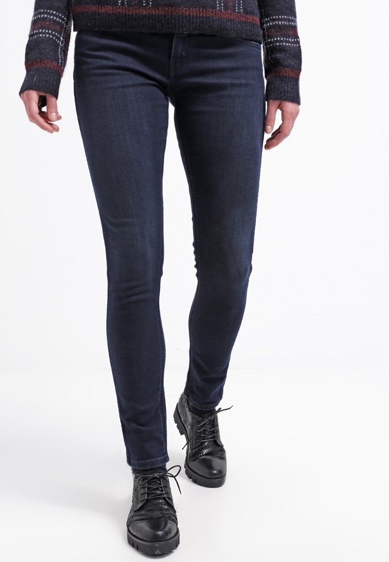 Smala jeans i mörk denim, med en klassisk passform. Bärs med svarta texturerade snörskor. Outfiten fulländas av en mönstrad tröja.