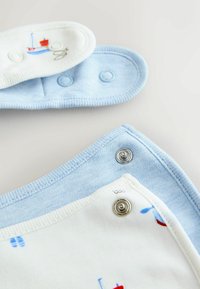 Bavoirs pour bébé avec boutons-pression, un en tissu bleu clair et un blanc avec de petits motifs de bateaux et poissons, présentés partiellement ouverts sur une surface blanche.