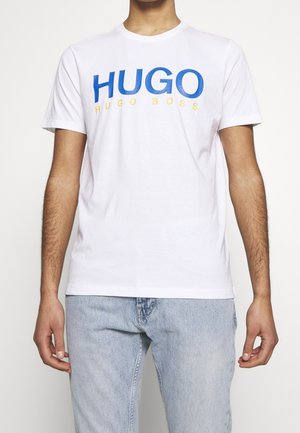 Biała bawełniana koszulka z niebieskim napisem "HUGO" i żółtą literą "HUGO BOSS". Krótkie rękawy, okrągły dekolt, standardowy krój, gładka tekstura.