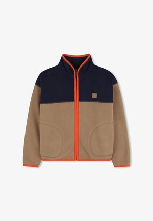 Fleece jakna s gornjim dijelom u tamnoplavoj boji, donjim dijelom u boji bež, narančastim patentnim zatvaračem i ukrasima. Ima dva prednja džepa i podignutu kragnu.