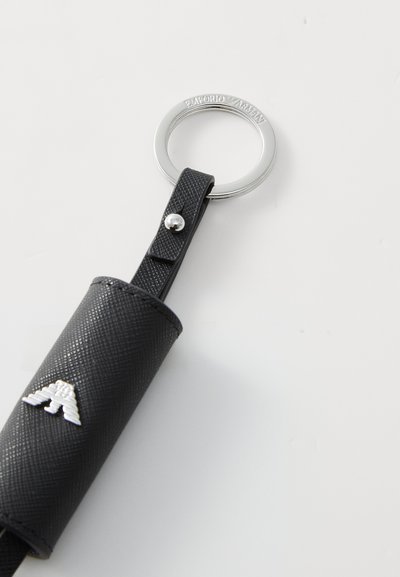 Black keychain holder with textured leather, featuring a silver ring and button closure, adorned with a silver emblem on the front.