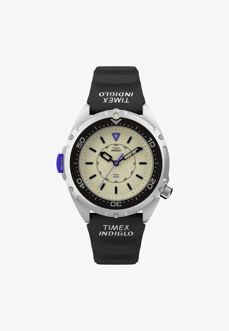 Timex INDIGLO kell, millel on kreemivärvi kellapealne, must silikoonist rihm ja hõbedane roostevabast terasest korpus. Omab helendavaid näppe ja pöörlevat kasutust.
