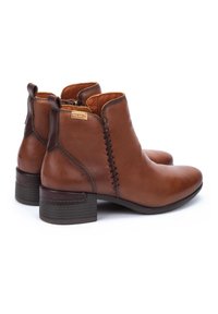 Braune Leder-Stiefeletten mit gesticktem Design, runder Zehenpartie und Blockabsatz. Das Innere ist mit einem kontrastierenden braunen Material ausgekleidet.