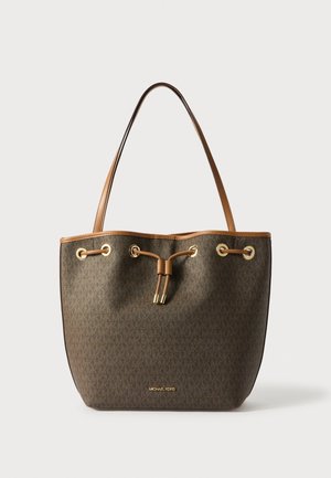 Sac cabas marron Michael Kors avec garniture en cuir, œillets dorés et fermeture à cordon, présenté sur un fond clair uni.