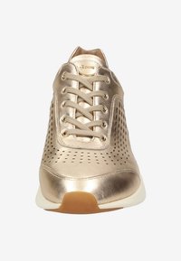 Guldmetalliska sneakers med perforerat mönster, som har snörning framtill och en vit sula, som visar en slät, blank yta.