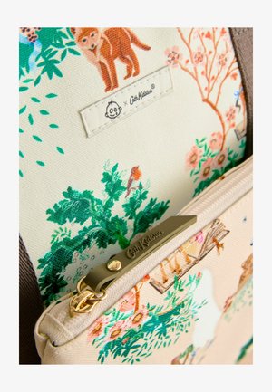 Gėlėmis raštuota audinio kišenė su kreminiu fonu, kurioje pavaizduoti gyvūnai ir augalai. Aukso detalių su prekės ženklu užtrauktukas.