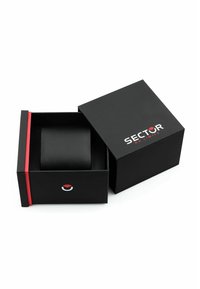 Scatola regalo rettangolare nera con un accento rosso. La scatola è parzialmente aperta, rivelando un oggetto cilindrico nero all'interno, marchiato con "SECTOR."