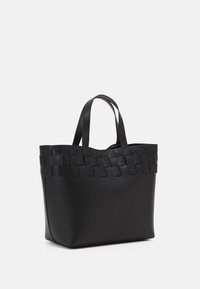 Svart tote-väska i slät läder, med ett vävt läderdesign upptill och två robusta handtag för bärande.