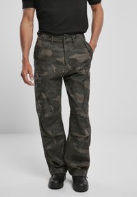 Pantalones cargo camuflados en tonos de verde oscuro y gris, con bolsillos laterales, cierre de cremallera y un corte holgado. Fabricados en un material de algodón duradero.