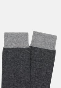 Šedé bavlněné ponožky s lehce šedým žebrovaným lemem, mají texturované tmavě šedé tělo a jsou navrženy v jednoduchém, klasickém stylu.