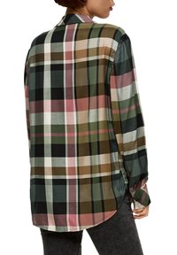 Camicia a maniche lunghe a quadri con motivi a check verdi, marroni, neri e rosa. Tessuto morbido, colletto classico, orlo curvato e dettagli con bottoni.