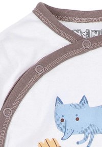 Witte babyromper met grijze rand en drukknopen, met een blauwe cartoonvos en een deel van een oranje dierenpootafdruk.