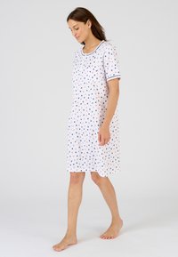 Camisa de noche de manga corta en tejido blanco con un estampado de corazones coloridos, que presenta un cuello henley y un borde de contraste en navy en las mangas.