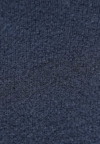 Tissu tricoté bleu marine avec une surface texturée, présentant un tissage fin et régulier et une apparence douce.