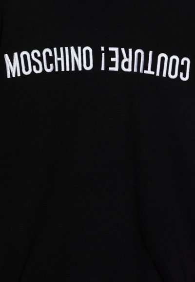 Μαύρο φούτερ με λευκή χρυσοκέντητη επιγραφή που γράφει "MOSCHINO COUTURE!" σε οριζόντια διάταξη. Μαλακό ύφασμα, κανονική εφαρμογή, χωρίς επιπλέον σχέδια.