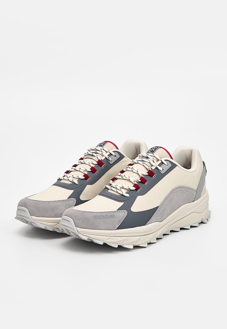 Baskets légères avec une tige en toile beige, des accents en daim gris, des lacets rouge et blanc, et une semelle en caoutchouc blanc texturé.