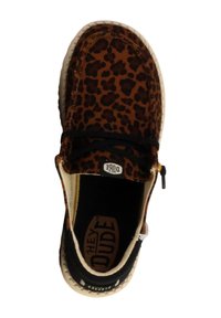 Chaussure à enfiler à imprimé léopard avec un tissu marron, des accents noirs, une semelle blanche et un dessus en textile. Présente un logo au talon et des lacets élastiques.