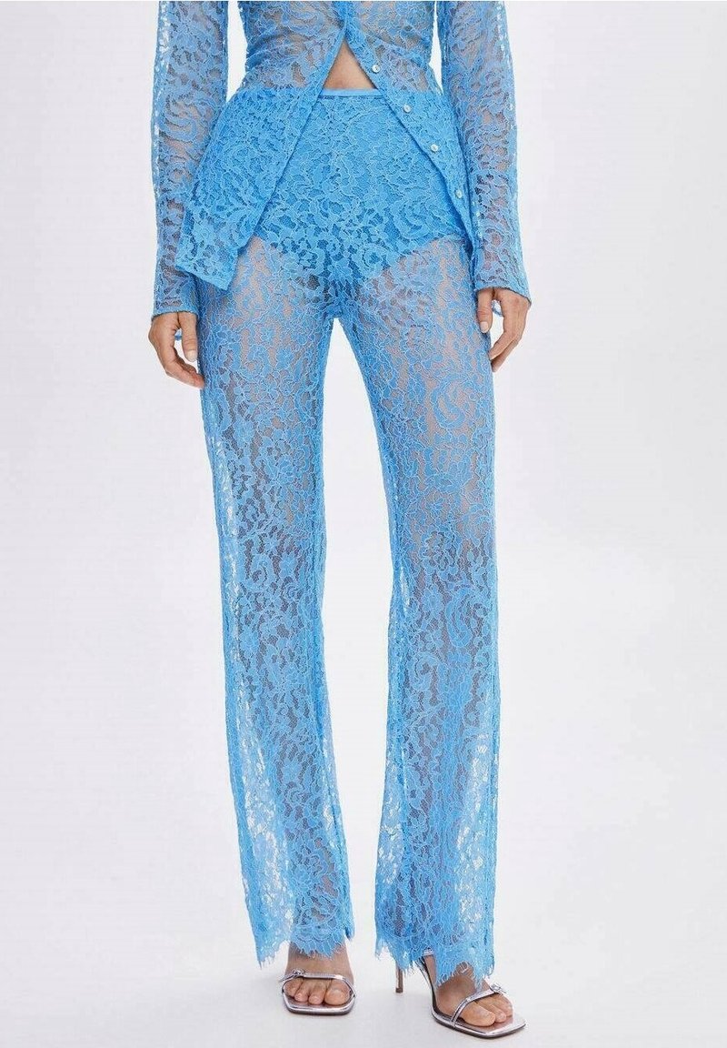 Blauwe kant tweedelige outfit met een lang mouw, peplum-top en wijde broek. De stof heeft een bloemenpatroon en een semi-doorzichtige textuur.