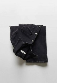 Črna denim srajca, zložena, z gumbi in žepom na levi strani prsnega dela. Tkanina ima gladko teksturo z rahlim sijajem.