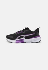 Sneaker de sport noir avec tige en maille, accents violets, semelle intermédiaire blanche et semelle extérieure avec une adhérence prononcée. Dispose d'un système de laçage et d'une languette d'enfilage.