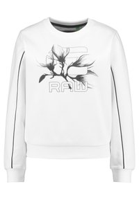Sudadera blanca con un gráfico floral negro y texto "RAW". Incluye ribetes negros en las mangas y un diseño de cuello redondo.