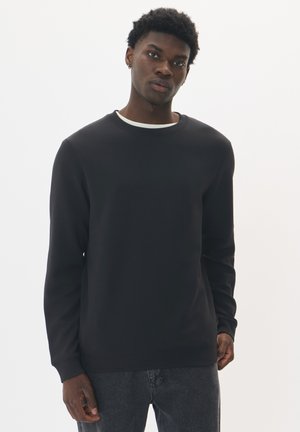 Czarny sweatshirt z okrągłym dekoltem i długimi rękawami, charakteryzujący się minimalistycznym wzornictwem oraz białym wewnętrznym kołnierzykiem. Gładka tekstura.