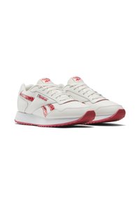 White athletic shoes with red accents and a textured design. Features a smooth leather upper, lace closure, and rubber outsole with prominent tread.