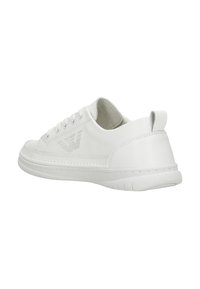 Bílá teniska ze syntetického materiálu s hladkou texturou, šněrováním a perforovaným logem na boku. Jemná patní štěrbina.