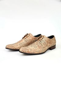 Bruine leren schoenen met paisleypatroon, ronde neus, bruine veters en lage zwarte hak. Gegraveerde textuur benadrukt de ontwerpdetails.