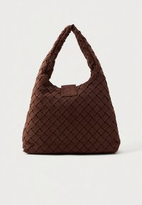 Καφέ υφαντή τσάντα ώμου με σχέδιο χόμπο, που διαθέτει παχύ πλεκτό χερούλι και υφή επιφάνειας, ολοκληρωμένη με τετράγωνο δερμάτινο διακοσμητικό.