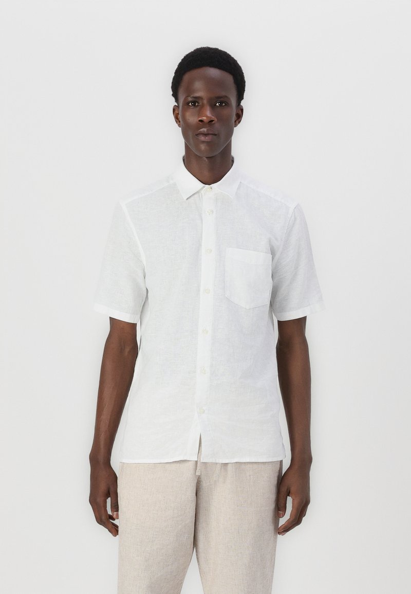 Camicia bianca a maniche corte in tessuto leggero, con colletto a punta, taschino sul petto e una vestibilità rilassata. Presenta dettagli di texture sottili.
