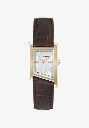 Rectangular gold-tone Ferragamo watch with silver dial, minimal gold hour markers, and dark brown leather strap with crocodile texture.