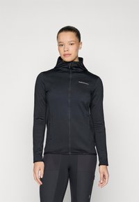 Juodas zip-up džemperis su kapu, pagamintas iš lygaus audinio. Yra dvi šoninės kišenės, prigludusi forma ir minimalus logotipo detalizavimas ant krūtinės.