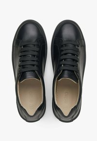 Černé kožené tenisky s kulatými špičkami, texturovanými tkaničkami a hladkým povrchem. Vnitřek obsahuje světlou stélku s logem.