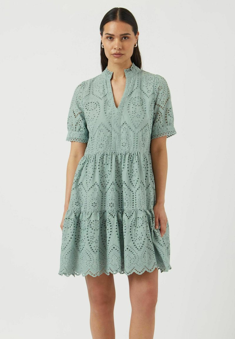 Svetlo modra obleka s plastenjem krila, kratkimi nabranimi rokavi, V-izrezom ter zapletenimi detajli iz očesa ob tkanini in robu.