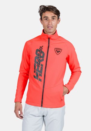 Bright orange zip-up jacket with black logo and text, featuring a high collar and fitted design, made from smooth, stretchy material.