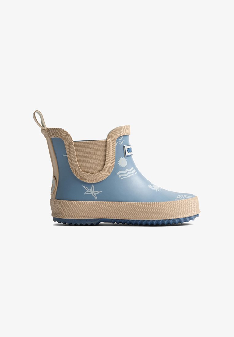 Botte de pluie pour enfants bleu et beige avec imprimés blancs à thème marin, semelle texturée antidérapante et languette à l'arrière.