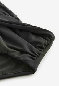 Zwarte stof met een gladde, glanzende textuur; geplooide details aan de rand; nette stiksels; geen zichtbare patronen of harde delen.