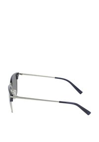 Okulary przeciwsłoneczne Nautica z prostokątną plastikową ciemnoniebieską oprawką, szarymi szkłami, srebrnymi metalowymi detalami i opływowymi, wygiętymi zausznikami.