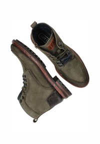 Groene leren enkellaarsjes met een gestructureerde afwerking, een bruine houten zool en donkerblauwe veters, voorzien van een achterste trekstrip en een geweven accent.
