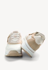 Baskets à lacets en cuir blanc et beige, dotées d'une touche de zip et d'une semelle matelassée avec un extérieur texturé. Bout rond et talon carré.