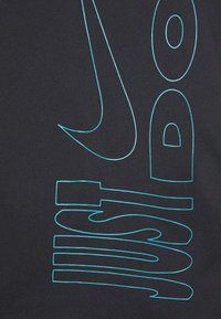 Letras contorneadas en azul formando la frase "HAZLO" sobre un fondo de tela oscura, enfatizando una tipografía audaz y moderna.