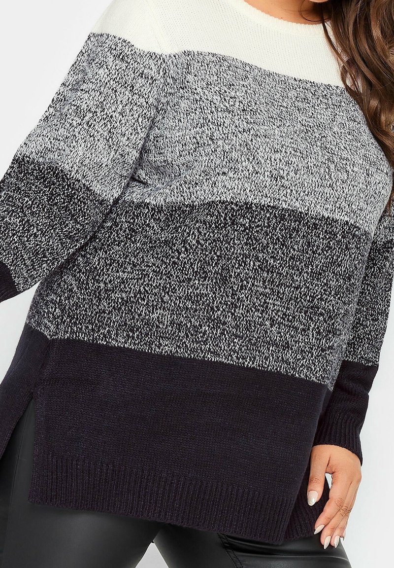 Stickad tröja med färgblockdesign; toppen är krämfärgad, mitten grå och botten marinblå. Har en avslappnad passform och sidoficka.